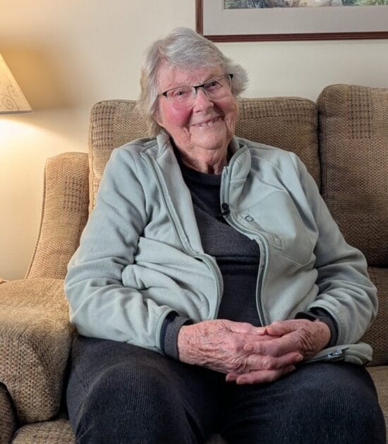 Pam sitting at home smiling at the camera